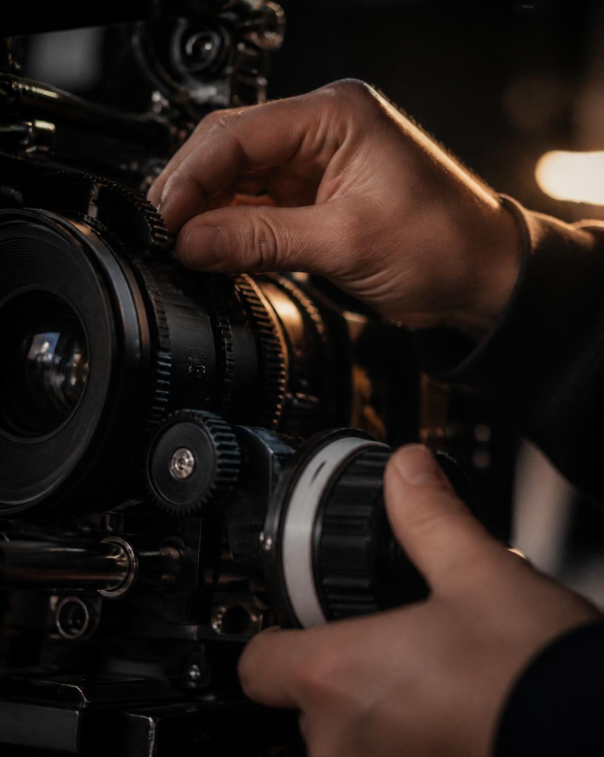 Focus puller adjusting a cinema lens on set